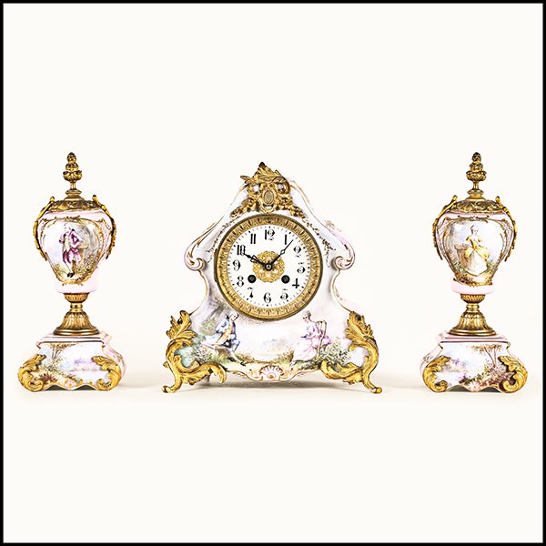 Marti mantel clock in porcelain with twin garnitures.